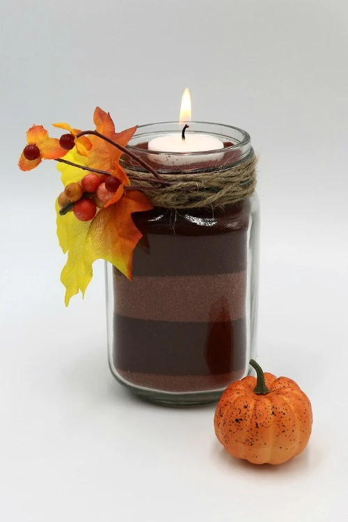 Use colored sand to create a colorful mason jar candle display for fall decor and fall entertaining!
